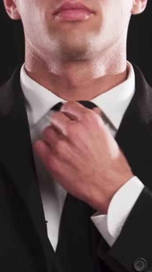Man Adjusts Tie, Close Up on Formalwear