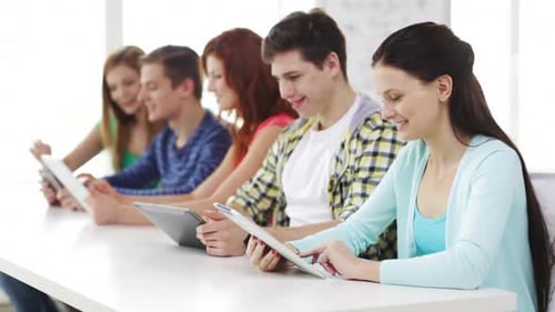 Glückliche Schüler nutzen Tablets für modernen Unterricht und Teamarbeit in der Schule