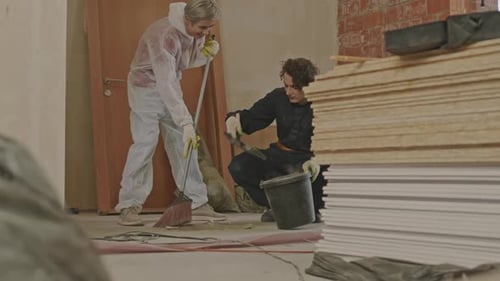 Workers Cleaning up Construction Dust in Renovating Apartment