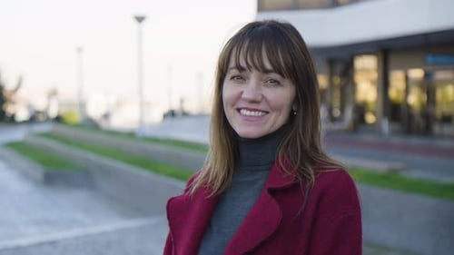 An Attractive Middleaged Caucasian Woman Smiles at the Camera in an Urban Area Ends in Closeup