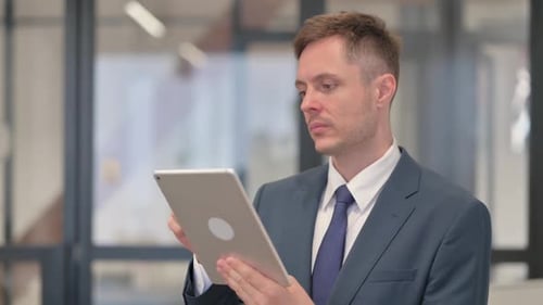 Man in Suit Using Tablet in Office