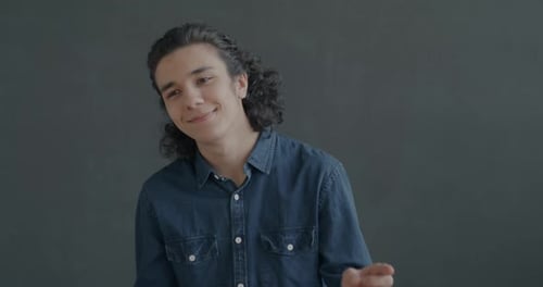 Smiling Young Adult Dances Against Dark Gray Backdrop