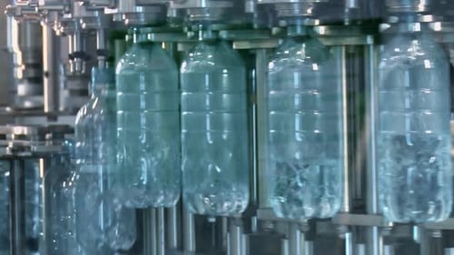 Neue Plastikflaschen auf dem Förderband einer Trinkwasseranlage. Klares Wasser aus einem tiefen Brunnen