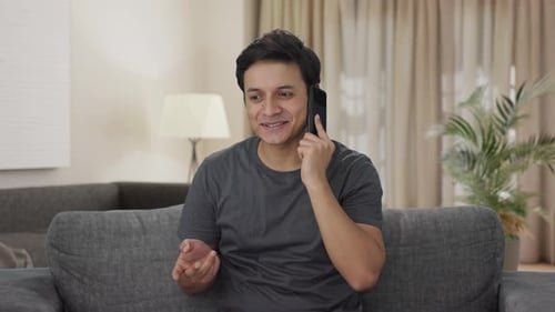 Man Smiling and Talking on Mobile Phone at Home