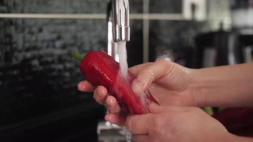 Washing a Red Pepper Under Running Water