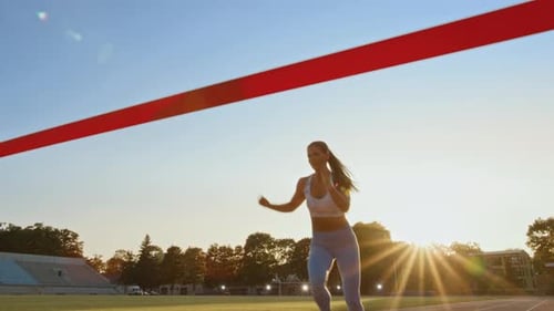 Beautiful Fit Female Runner Crossing the Finish Line on a Professional Sports Arena. Athletic Woman