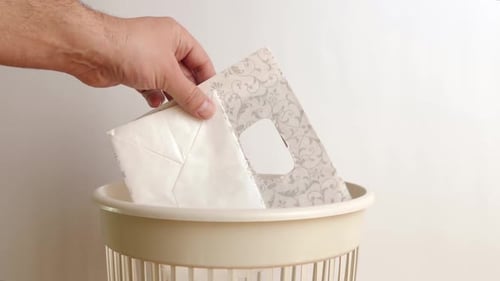 E273 1Die Papiertüte wird in den Müll geworfen. Das Konzept der Entsorgung und Wiederverwertung.