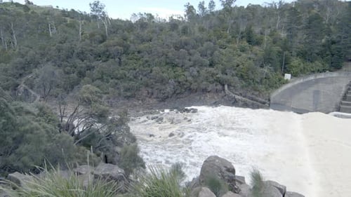Statische Aufnahme von Wasser, das auf dem Damm fließt. Hochwasser. Der Flusskanal.
