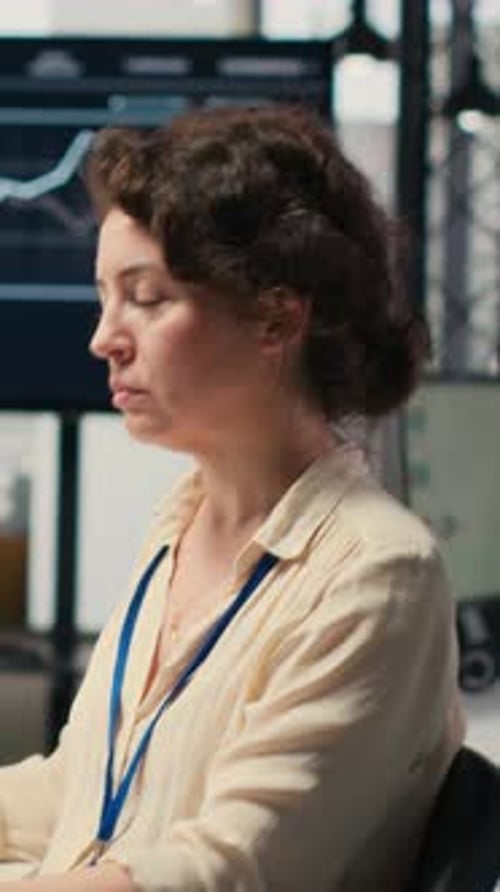 Vertical Video Young Businesswoman Focused on a Podcast While She Resolves Office Tasks