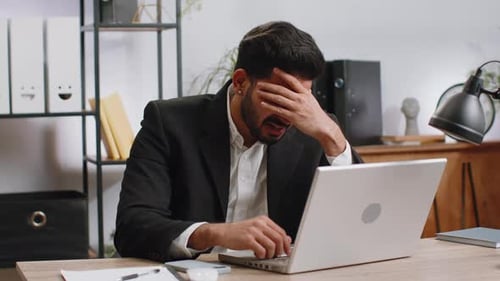 Frustrated Young Adult Yelling at Laptop at Desk