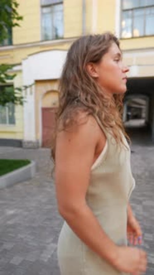 Strolling Through the City in Summer Fashion a Curlyhaired Girl Enjoys the Atmosphere