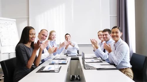 Smiling Team Applauding at Business Meeting in Office