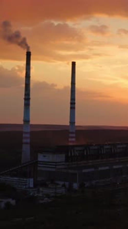 Industrial refinery with smokestack near a river. Amazing sunset at industrial zone. View from above