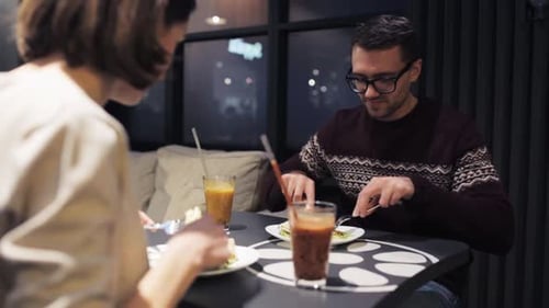 Couple enjoying food and drinks at cafe table