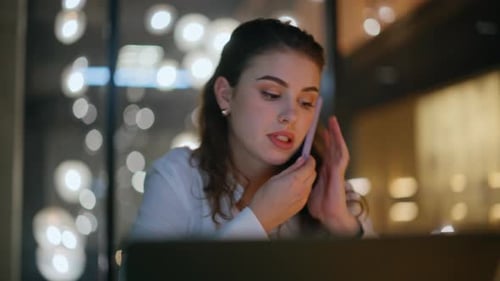 Woman Talking on Cell Phone Working Late