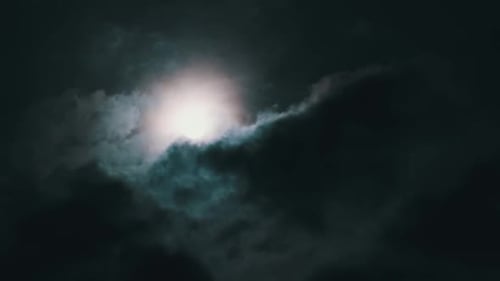 Dramatic Moon Rising Behind Thick Night Clouds