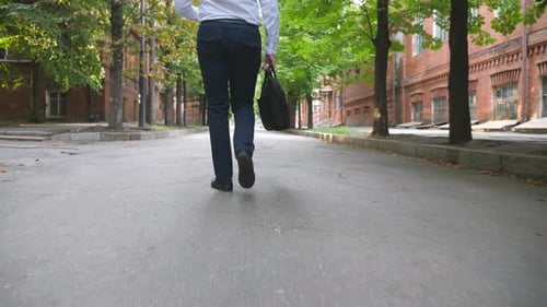 Back View to Legs of Confident Businessman in Formal Wear Going on Urban Street Unrecognizable