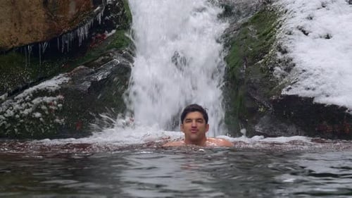 Man Bathes in Waterfall in Winter