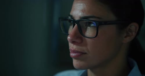 Portrait of a beautiful girl with glasses while she is working on a computer in an office. Concept
