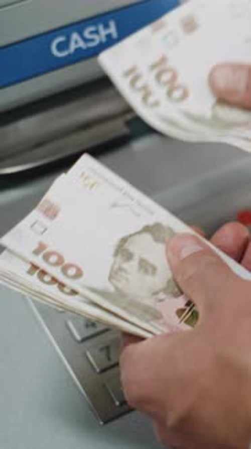 Unrecognizable Man Counting Hryvnia Bills After Withdrawing Cash From ATM Machine