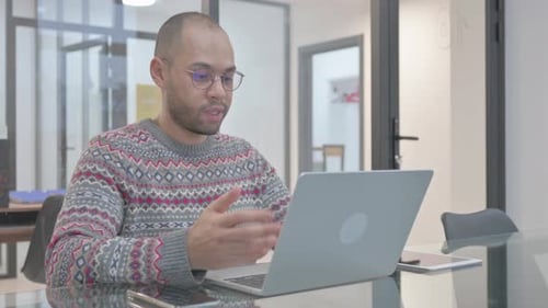 Young Adult Talking to Laptop During Video Meeting