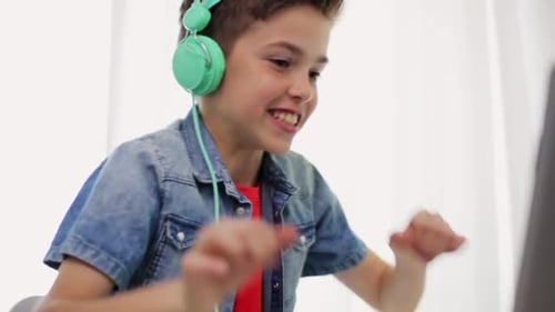 Jovem rapaz hispânico comemora vitória jogando videogame no laptop em casa