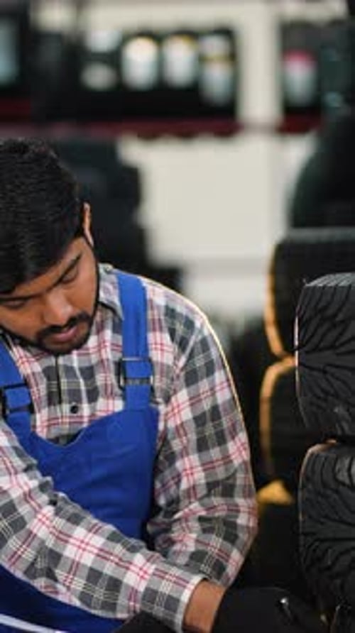 Indian Mechanic Checking Tire Inventory in Auto Repair Shop