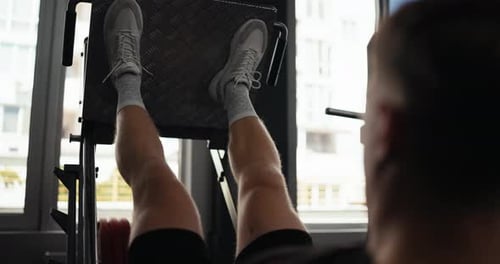 Over the Shoulder Up Close a Blond Guy in Gray Sneakers Performs a Bench Press During His Leg