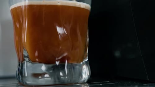 Coffee Pouring into Glass from Coffee Machine