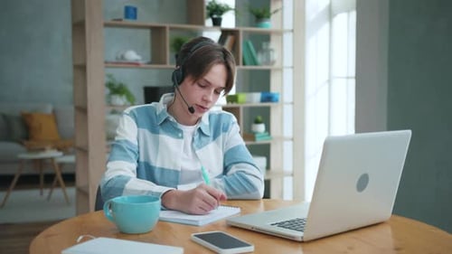 Young Adult Studying with Laptop and Headset