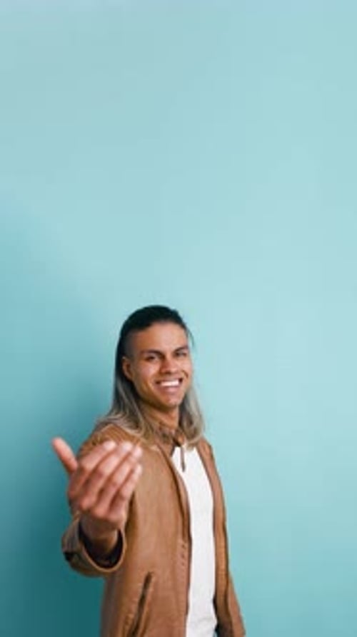 Charismatic Handsome Man Inviting to Come Closer in a Studio Setting Vertical