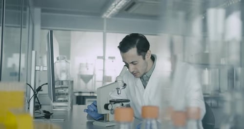 Male Scientist using Microscope in Laboratory