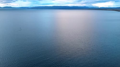 Gewellte Wasserlandschaft, umgeben von der Bergkette.