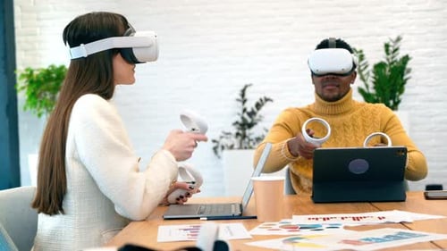 VR-Geschäftskonferenz in einem Büro. Ein schwarzer Mann und eine kaukasische Frau mit VR-Brille
und Steuerung
