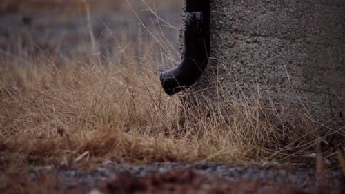 Water Dripping From Downspout Into Dry Grass At Farm. closeup shot