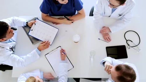 Medical Professionals Collaborate Around Table in Meeting