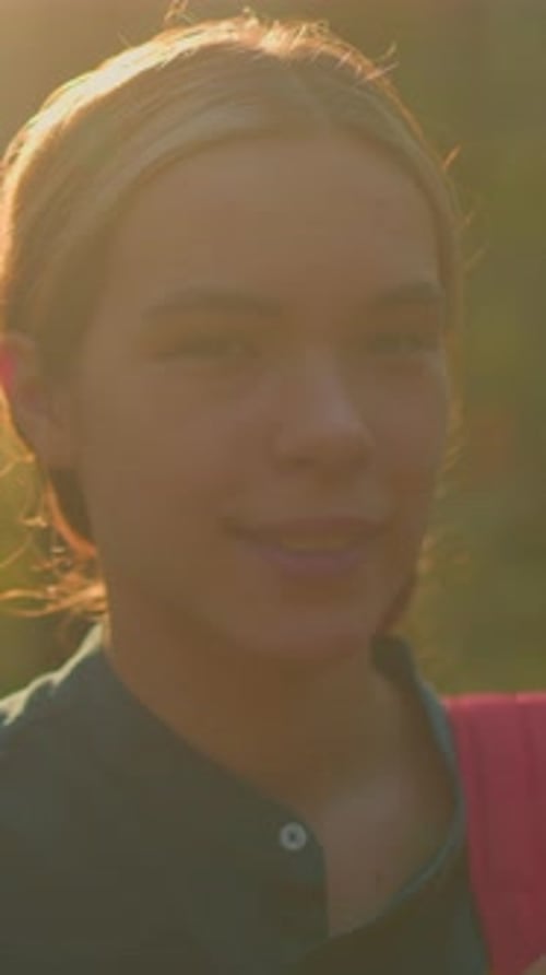 Jeune randonneur souriant dans une forêt ensoleillée avec une lueur radieuse