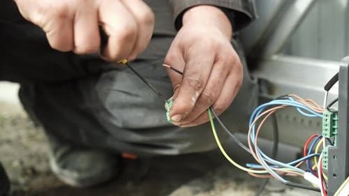 Man connecting electrical wires with screwdriver