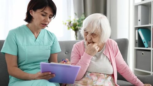 Doctor Reads Elderly Woman Health Documents