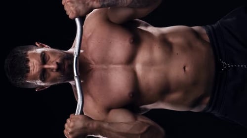 Fitter und sportlicher Bodybuilder auf schwarzem Hintergrund Bodybuilder-Training mit Langhantel Das Konzept von
