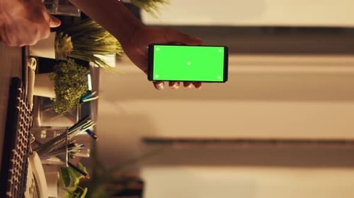 Hand Holding Horizontal Phone with Green Screen