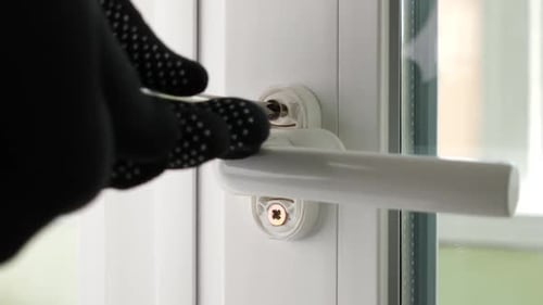 Gloved Hand Repairing White Window Handle With Screwdriver