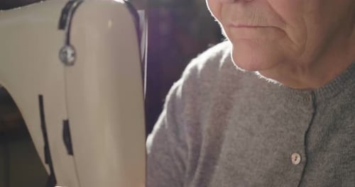 Senior Woman Sewing on Vintage Sewing Machine