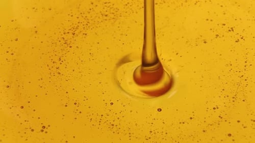 Liquid Honey of Golden Color a Trickle of Golden Honey Flows Into the Honey