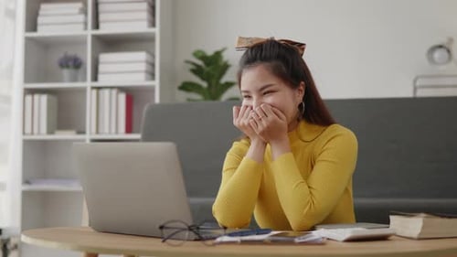 Woman Laughing at Laptop in Home Office