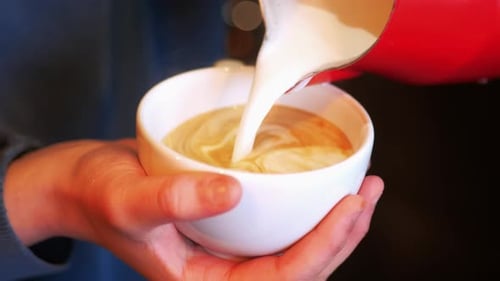 Pouring Creamy Milk into Coffee Cup for Latte Art