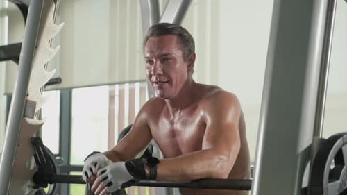 Sweaty Shirtless Sportsman Having Rest after Doing Exercises at Gym