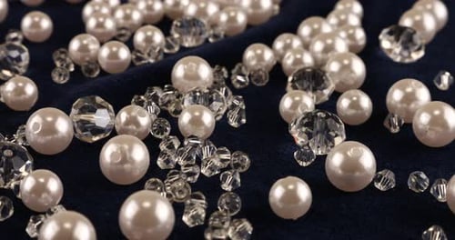 Transparent white jewelry crystals, rhinestones and pearls on blue velvet.