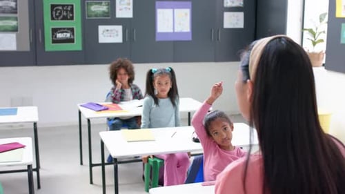 In school, students raising hands in classroom, engaging with teacher