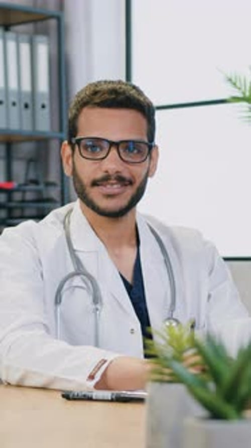 Man in Lab Coat Smiling in Doctor's Office